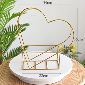 Detail of a golden heart-shaped metal floral frame with dimensions on a white display stand