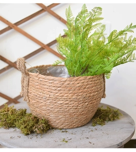 Detail view of woven straw flower pot with waterproof lining and sturdy hemp rope handle
