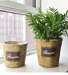 Detailed texture of hand-woven seagrass planter with Flowers patch and green plant decoration