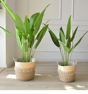 Detailed view of woven straw planter basket with decorative fringe and dual handles