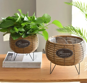 Detail of woven rattan plant pots with black metal legs and waterproof plastic liners