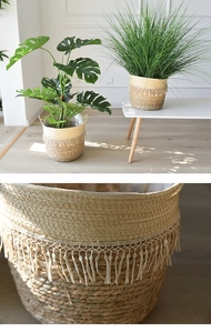 Close-up of woven straw plant pot with cream tassels and natural seagrass texture