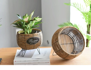Detail of hand-woven rattan planter with black tripod stand and waterproof liner