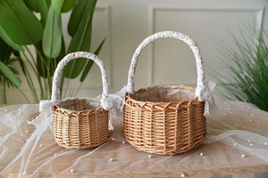 Macro detail of natural willow flower baskets with white lace handles and bows on wood