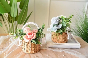 Detail of handmade wicker flower baskets with white lace trim and faux roses