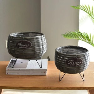 Handwoven straw planters set with black metal tripod stands and waterproof inner linings