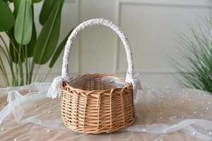 Detail of hand-woven wicker flower basket with white lace bow and handle decoration