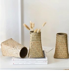 Detailed close-up of three handmade straw woven vases for dry flower arrangements