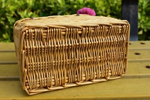 Close-up of hand-woven wicker basket texture and natural wood grain on a yellow bench