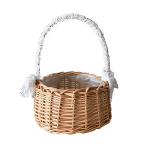 Handmade wicker flower basket with white lace handles and bows for wedding decor