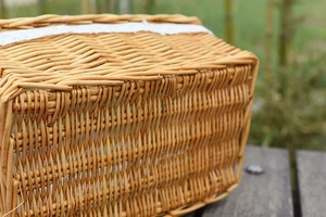 Close-up of rectangular woven wicker basket featuring elegant white lace trim detail