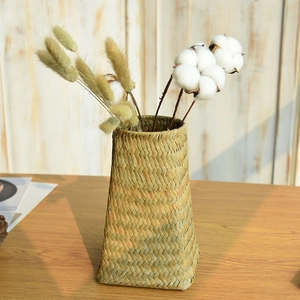 Handwoven seagrass flower vase with dried cotton and rabbit tail grass on wood table