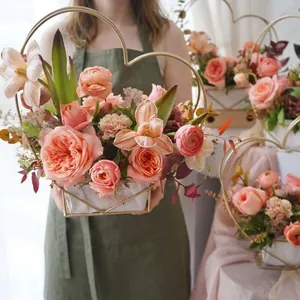 Golden heart-shaped metal flower basket with pink roses and elegant greenery arrangement