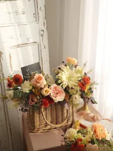 Detail of a vintage wicker basket filled with pink roses and yellow sunflowers