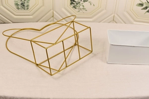 Detail of golden heart-shaped metal frame with white rectangular inner tray