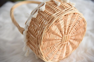 Macro detail of the woven rattan texture and white tassel trim on the handmade basket