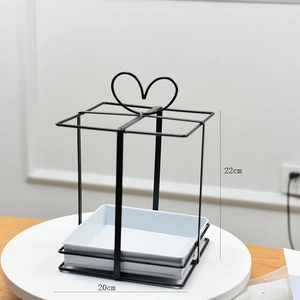 Detail view of 22cm high black metal flower basket stand with heart-shaped top and white base