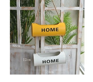 Close-up of wall-mounted metal planters with hemp rope and black HOME lettering