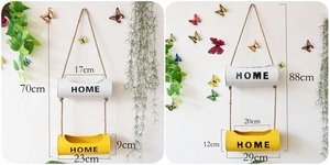 Detail view of rustic wall hanging metal flower pots with HOME text and rope hangers