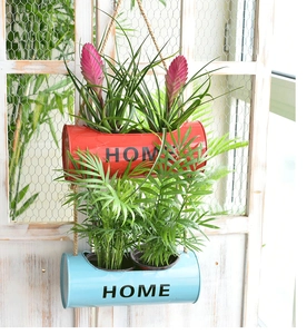 Detail of red and blue metal wall planters with hemp rope and HOME engraving