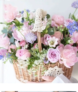 Macro detail of hand-woven wicker basket featuring delicate lace handle and fresh pink roses