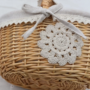 Handwoven wicker storage basket with white lace lining and floral crochet decoration