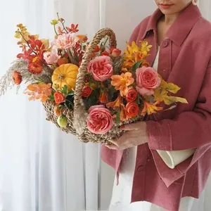 Cesto di fiori in paglia intrecciato a mano con rose autunnali e mini zucche decorative