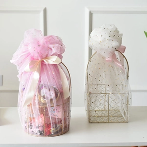Detail of round golden metal gift baskets with star-patterned mesh and decorative bows
