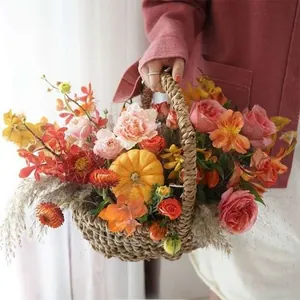 Dettaglio di un cesto di fiori intrecciato con rose, garofani e una mini zucca decorativa