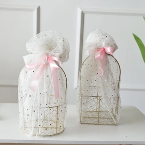 Detail of round golden metal gift basket with star mesh fabric and pink silk bow