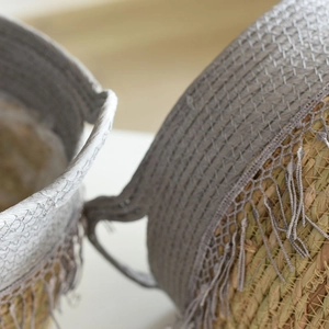 Handwoven straw storage basket with grey crochet lace trim and bohemian tassels