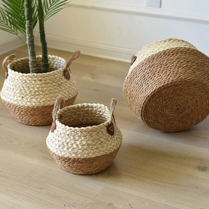 Detail of woven seagrass storage baskets with bicolor design and brown leather labels