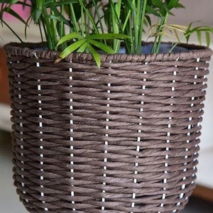 Minimalist dark brown woven floor planter with green plant for indoor home decor