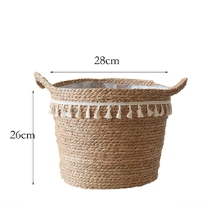 Detail of bohemian seagrass planter basket with white tassels and internal plastic lining