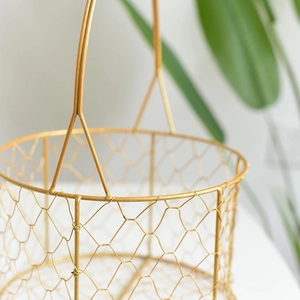 Close-up of golden iron round gift basket with elegant wire grid mesh and sturdy handle