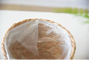 Close-up of hand-woven wicker basket featuring a transparent waterproof plastic liner
