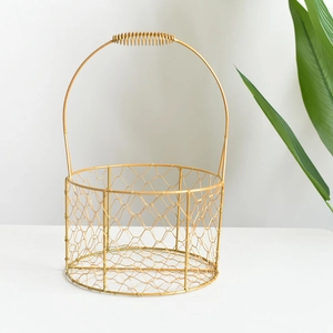 Golden round iron wire wedding gift basket with decorative spiral handle on white surface