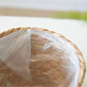 Nordic hand-woven straw plant pot with waterproof plastic lining and natural seagrass texture