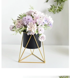 Detail view of purple faux hydrangea in a black metal pot with gold geometric tripod stand
