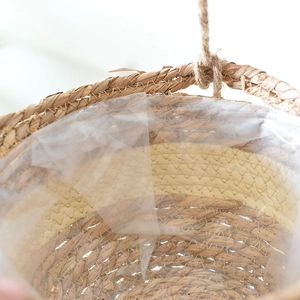 Detail of handwoven seagrass hanging planter featuring waterproof liner and sturdy hemp rope