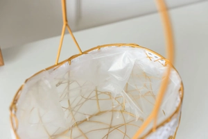 Detail of gold rectangular wire basket showing the mesh structure and waterproof inner lining