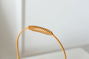 Detail of yellow metal basket handle featuring a spring-style anti-slip grip design