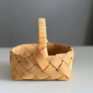 Détail d'un panier cadeau en bois tressé à la main avec poignée solide et fini naturel
