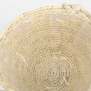 Close-up of woven straw plant basket with waterproof plastic lining and spiral texture