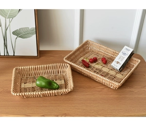 Detail of hand-woven rectangular rattan storage baskets in two sizes on wooden tabletop
