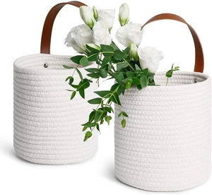 Detail of hand-woven cotton rope hanging baskets with leather handles and silver rivets