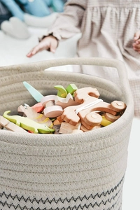 Detailed close-up of a woven cotton rope storage basket with animal toys inside
