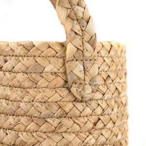 Close-up of seagrass woven basket handle with reinforced V-shaped stitching detail