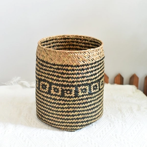 Detail of woven seagrass basket showing black geometric diamond patterns and texture