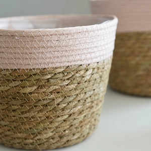 Handwoven seagrass plant basket with natural pink color blocking and z-stitch detail